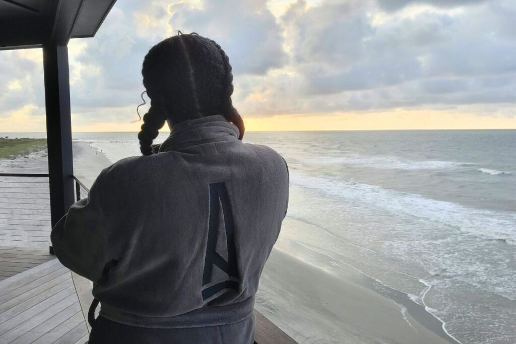 Simone Cheri on the primary balcony at A Ma Maniere Beach property in Folly Beach, SC